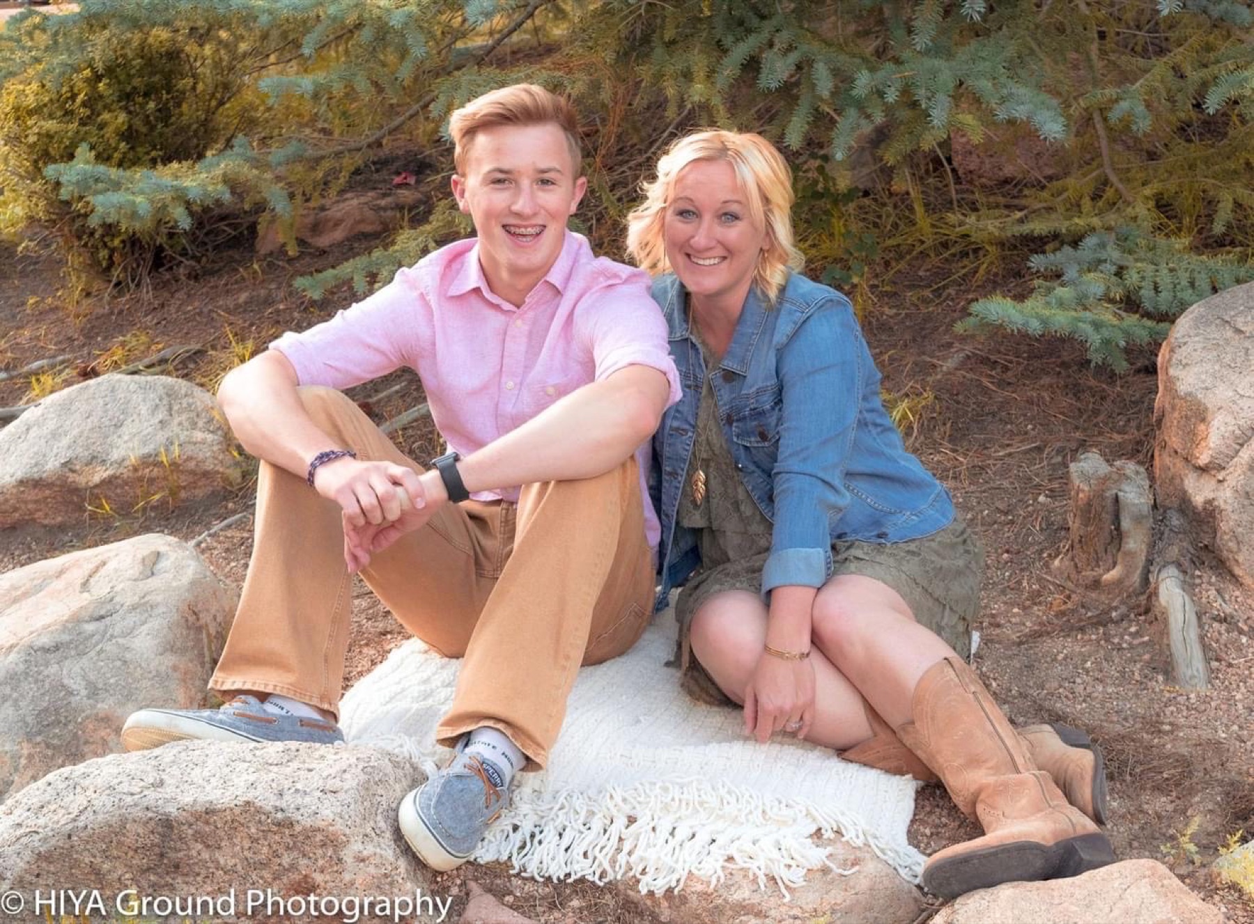 Two senior friends sitting on rocks